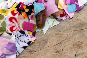 Scrap pieces of colorful fabric on the old wooden floor. photo