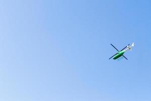 Green helicopter in the sky. photo