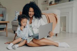 feliz madre africana y su hijo disfrutando de una videollamada con la familia foto