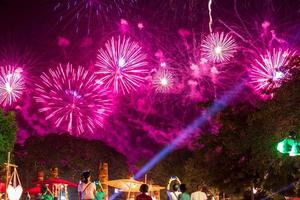 Fireworks over the trees and people at the festival. photo