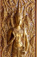 Golden angel statue on the temple door. photo