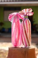 Bolsas de rayas rosas y blancas en botellas transparentes. foto
