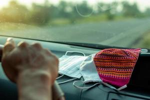 muchas máscaras faciales se colocan en el auto con las manos. foto