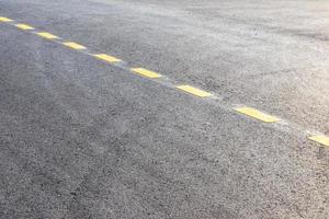 Paved surface with yellow dotted lines. photo