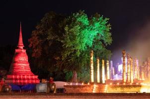 Old Buddhist temple at night with lights and smoke. photo