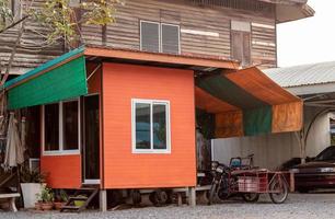 cabaña de habitación naranja cerca de la antigua casa de madera. foto