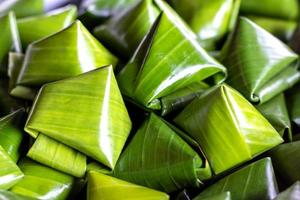 Dessert wrapped in banana leaves triangular. photo