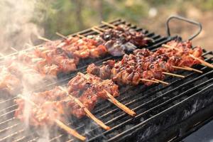 brochetas de pollo a la parrilla con humo. foto