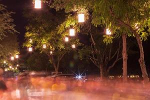 linternas en el árbol con movimiento borroso de personas. foto