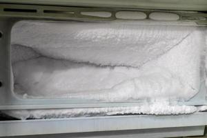 mucho hielo en el congelador del viejo refrigerador. foto