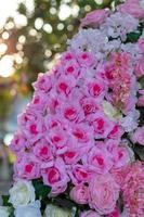 Many artificial bouquets of pink flowers with bokeh lighting.