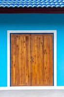 puerta de madera sucia y pared azul. foto