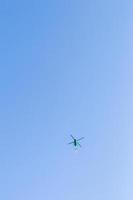 Green helicopter in the sky. photo