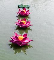 Foam lotus flower painted with pink over water. photo