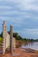 Many views of concrete columns near the river shore. photo