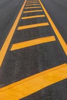 Yellow line symbol on a new paved road. photo