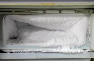 mucho hielo en el congelador del viejo refrigerador. foto