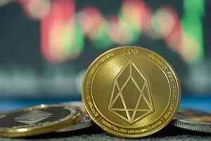 enfoque seleccione y desenfoque golden eos cash y ethereum eth group símbolo de criptomoneda y candelabro de gráfico de acciones en tabletas. utilice la tecnología cryptocurrency blockchain. con plusvalía, fundamental. foto