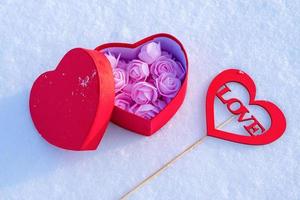 composición romántica en la nieve con un regalo y un mensaje amable foto