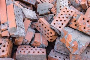 A pile of broken bricks after the demolition of a building. Landfill of old building material after structural failure photo