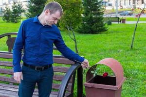 a sad man did not wait for his beloved and in desperation threw the rose into the trash photo