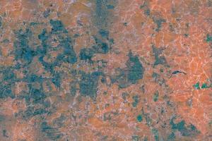 The texture of a worn and discolored concrete or iron wall with rust, damage and scratches photo