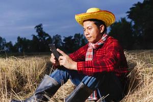 Asian farmer with rice stubble in the field photo