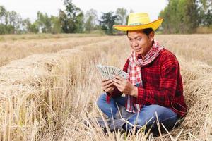 Asian farmer with rice stubble in the field photo