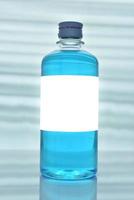 botella de plástico de alcohol con etiquetas blancas. foto