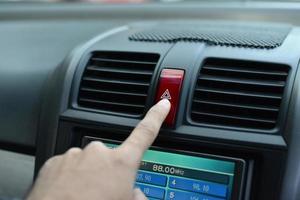 Finger on the Hazard Lights button. photo