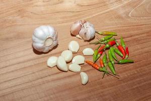 white garlic and Chili on wooden floor for cooking photo