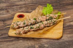 Raw minced pork skewer kebab for grill photo