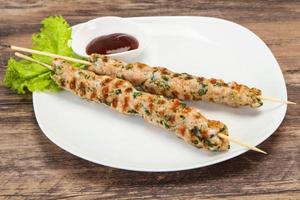 Minced pork skewer kebab with sauce photo