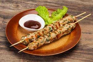 Minced pork skewer kebab with sauce photo