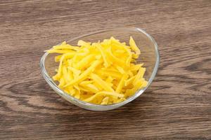 Shredded yellow cheese in the bowl photo