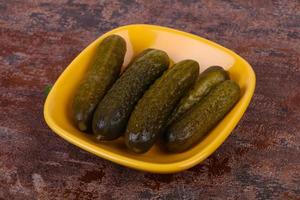 Pickled cucumbers heap in the bowl photo