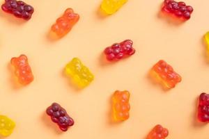 Colored jelly bears on an orange background. Top view photo