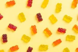 Colored jelly bears pattern on an yellow background. Top view photo