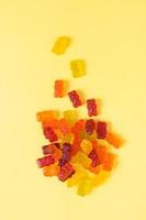 Colored jelly bears on an yellow background. Top view photo