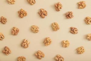 Pattern with peeled halves of walnuts top view. Food abstract background with nuts photo