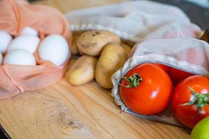 Colorful fresh fruits vegetables and eggs  in eco friendly bags photo