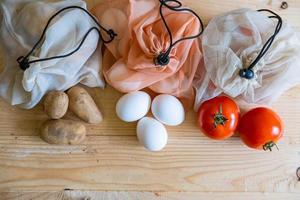 Colorful fresh fruits vegetables and eggs  in eco friendly bags photo