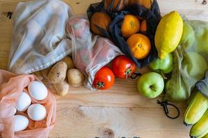 Colorful fresh fruits vegetables and eggs  in eco friendly bags photo