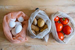 Colorful fresh fruits vegetables and eggs  in eco friendly bags photo