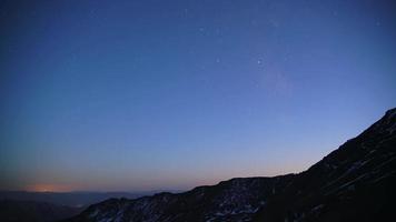 8k estrellas en el cielo pasando de día a noche en las montañas