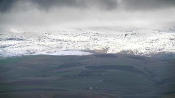 8k dunne laag sneeuw op boomloze heuvels in de winter video