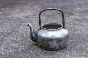 Classic old Kettle at put on concrete background. photo