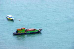 Traditional fishing boats and speed boats float in the sea after sending the tourists.