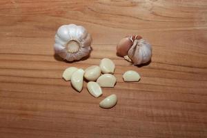 white garlic on wooden floor for cooking photo