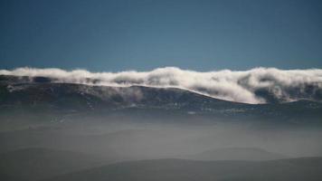 Nuage de brume 8k coulant le long de la crête de la chaîne de montagnes video